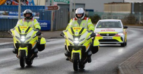 Two blood bikes side by side driving along road